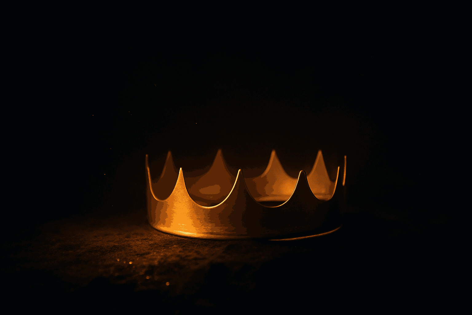 A golden crown resting on dark stone, glowing in warm light against deep darkness, the crown of life won through suffering.